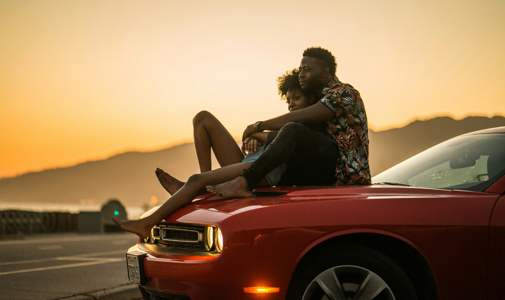 A Guide to Cultivating Healthy Relationships. Image of a couple sitting together on the hood of a red car.